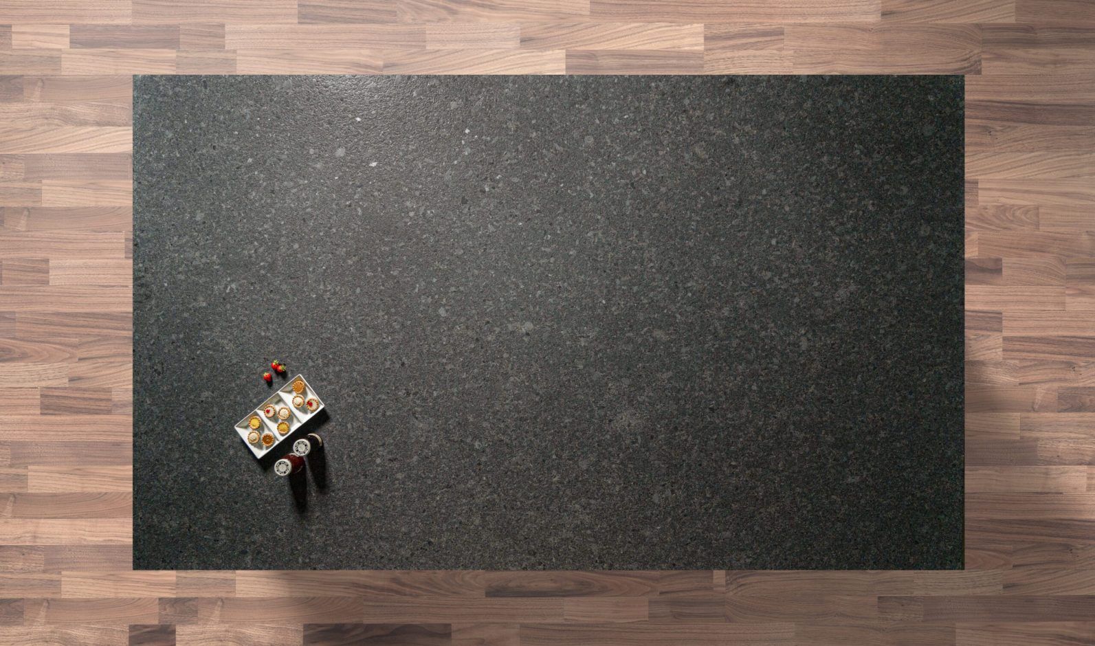 Overhead view of a Steel Grey leather Granite worktop showing fine speckling and a textured finish, photographed from above with a small styled tray in the corner.