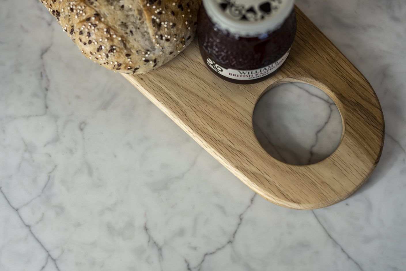Super White Quartz worktop close-up with soft grey veining beside a wooden serving board and breakfast items