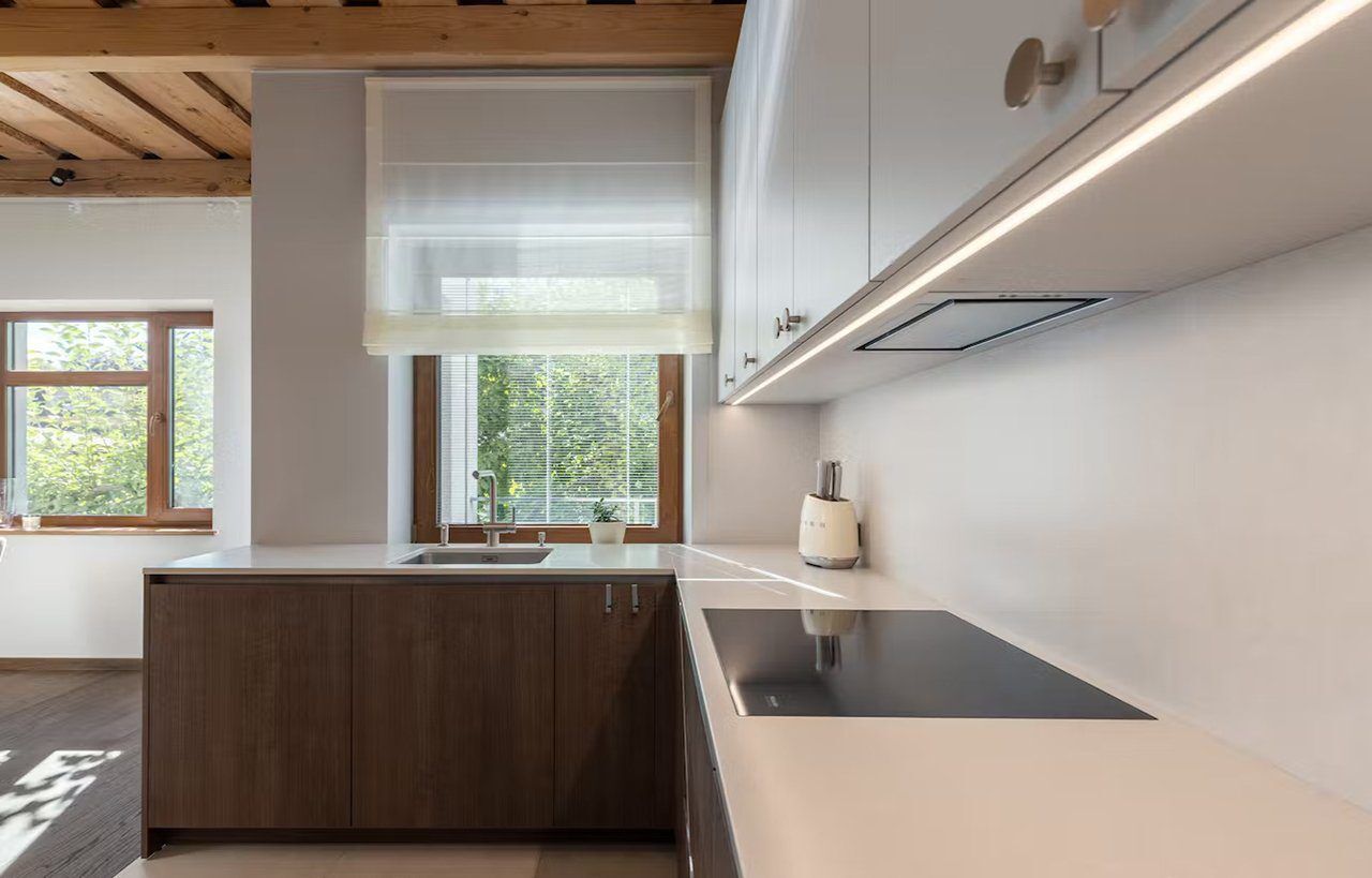 Desert Silver Quartz worktop by a window and hob showing pale grey surface with subtle veining in a modern kitchen setting