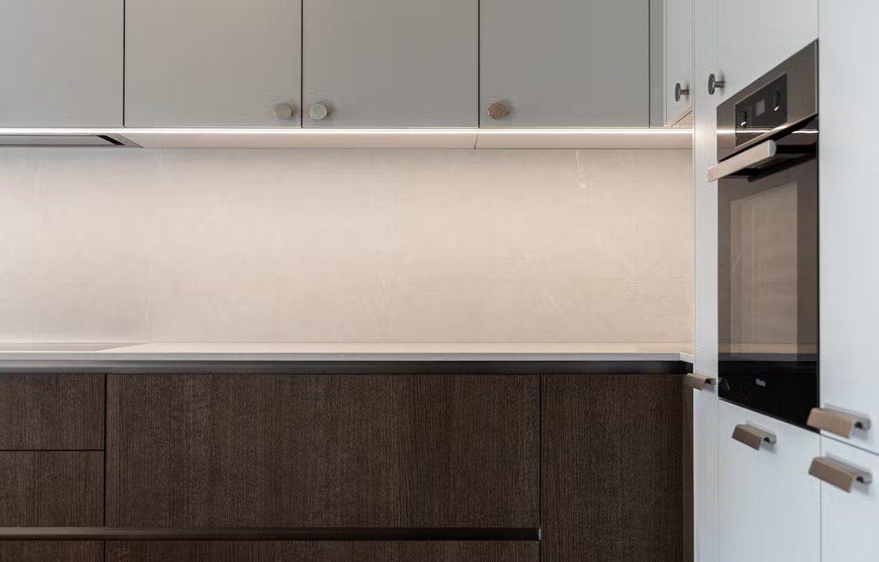 Desert Silver Quartz worktop run in a modern kitchen showing pale grey surface with clean straight edge and under-cabinet lighting