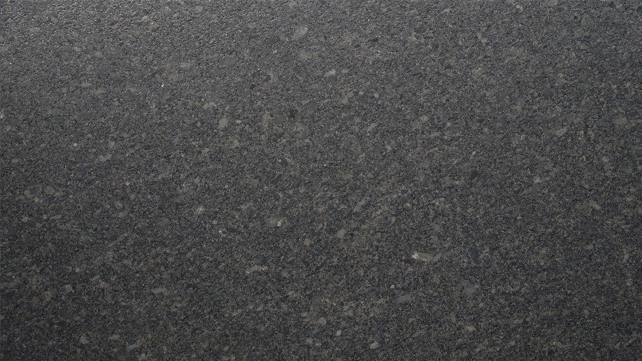 Close up slab photo of Steel Grey leather Granite showing fine speckling and a subtle textured finish across the dark grey surface.