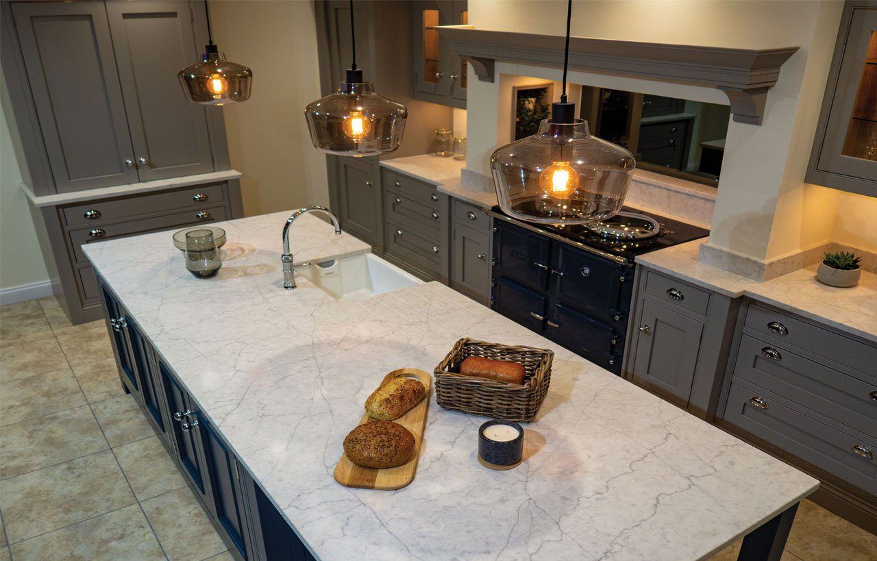 Large Super White Quartz island worktop with curved edge and light marble-effect veining in a modern kitchen