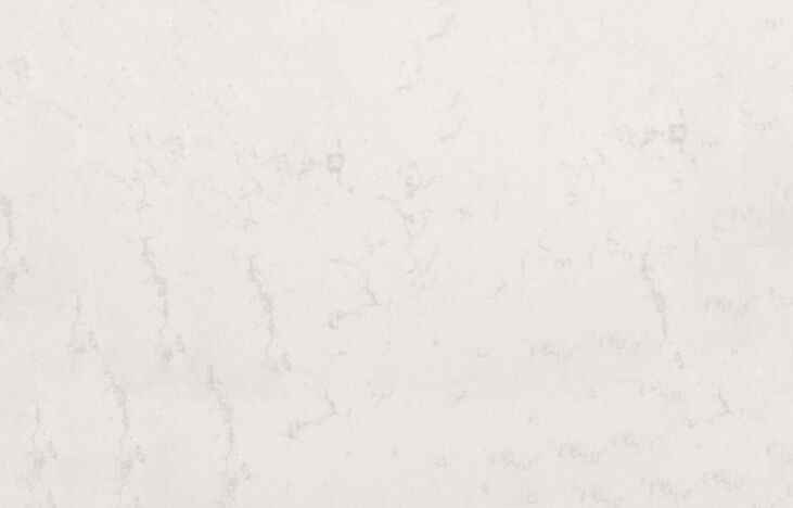 Close up of Carrara Quartz surface showing soft white background and light grey veining