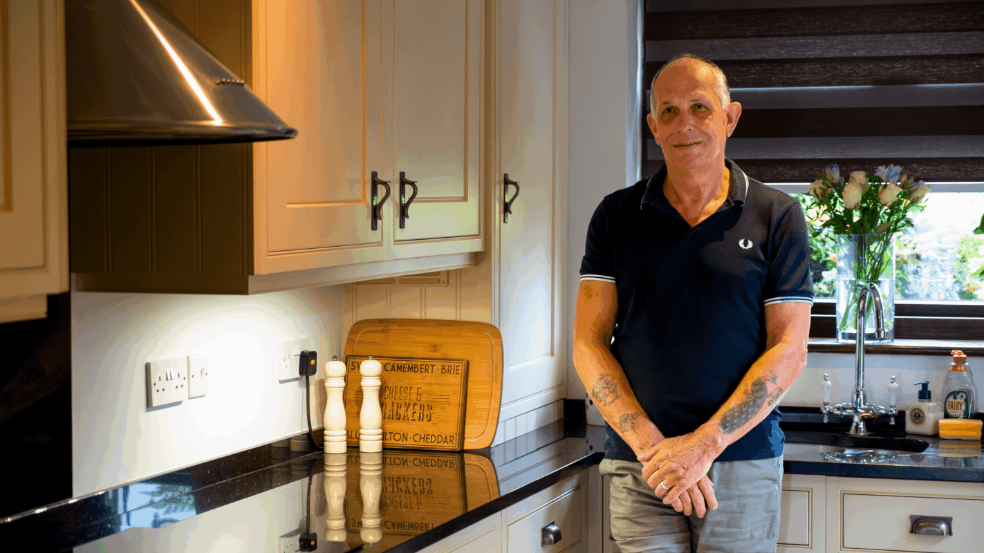 Testimonial video still of a customer standing in their kitchen after a Star Galaxy Granite worktop installation by Mayfair Worktops.