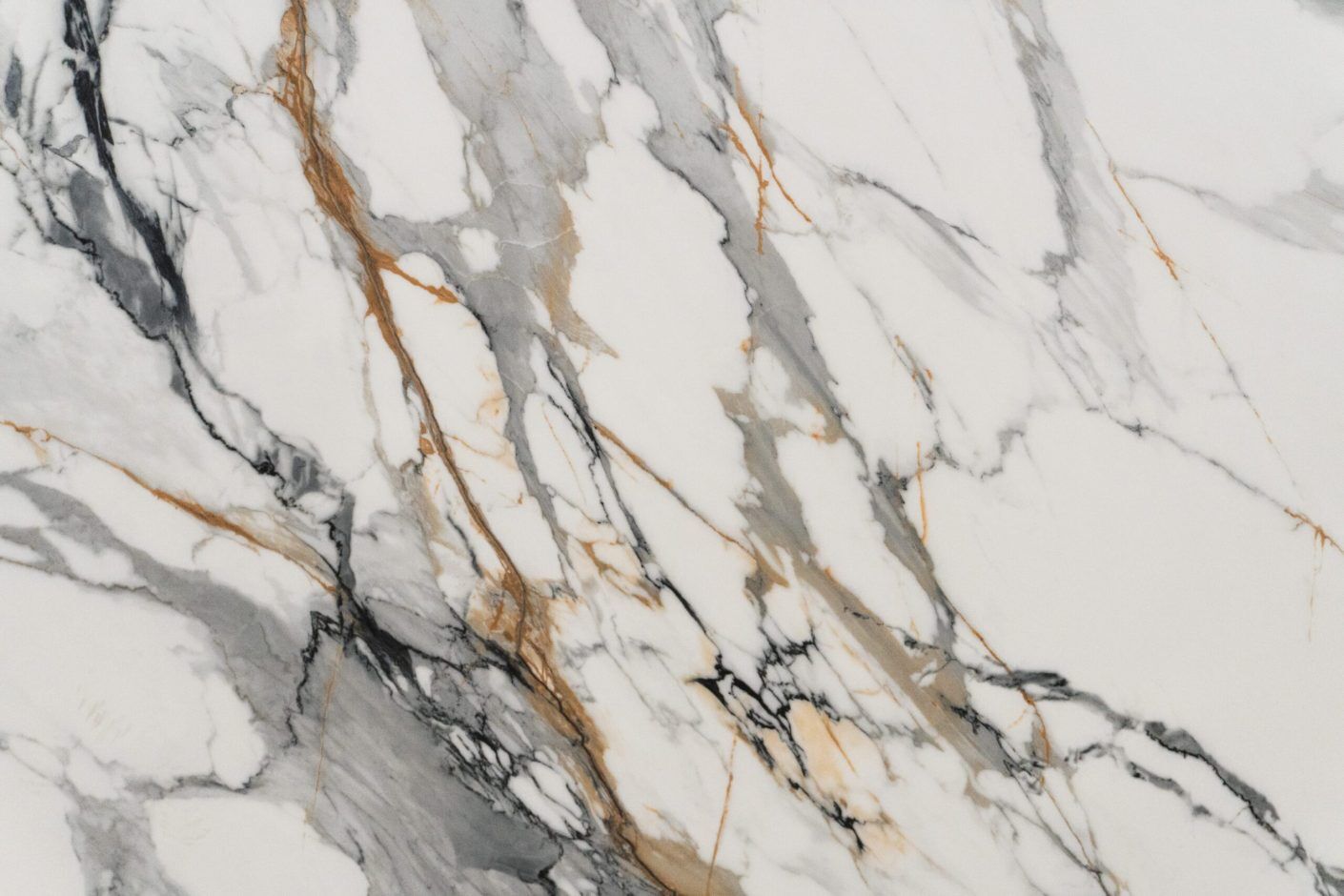 Calacatta Gold Borgnini Porcelain full slab on a display stand, showing a white marble effect background with grey veining and gold accents