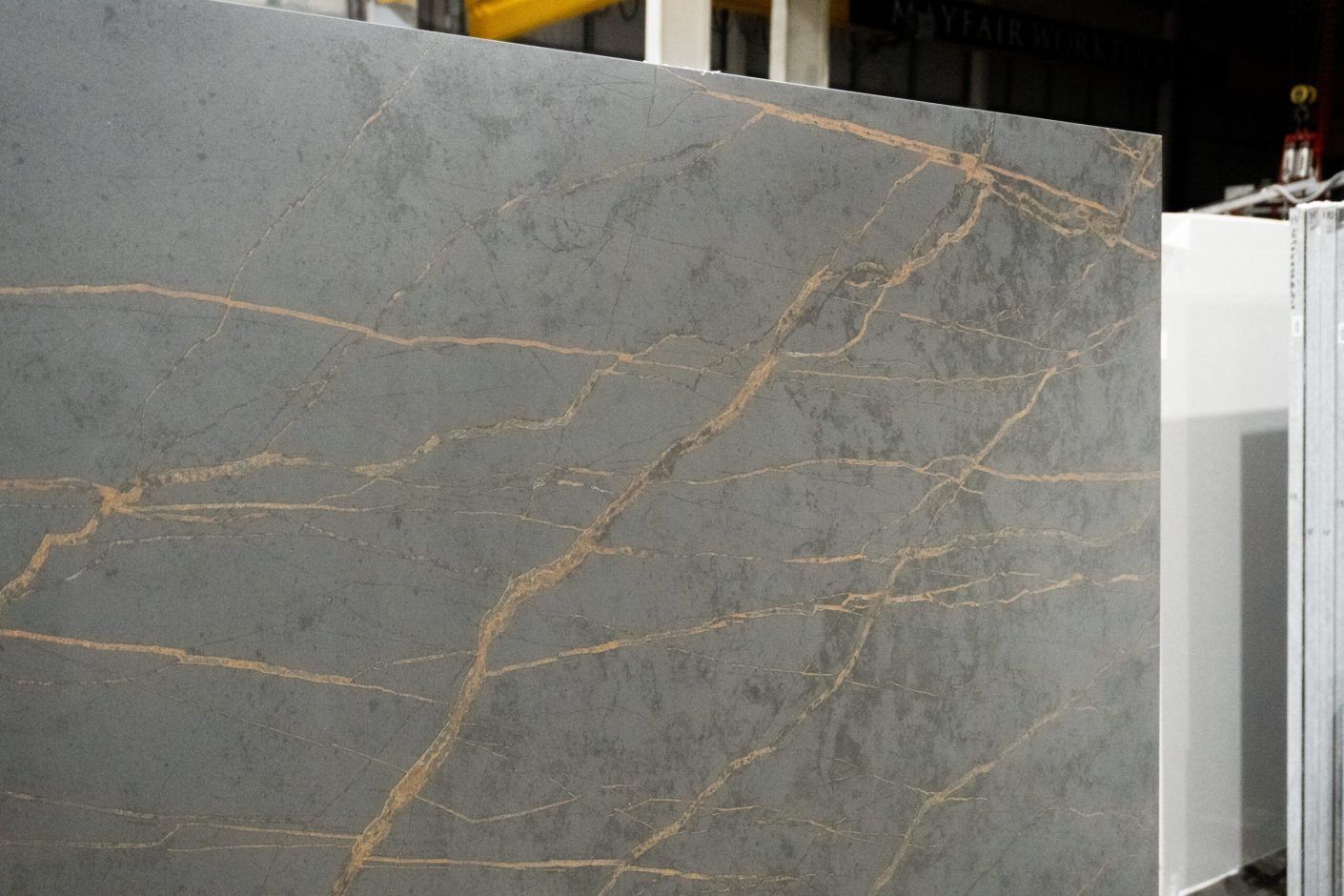 Gold Laurent Porcelain surface close-up with bold gold veining across a dark grey stone-look background