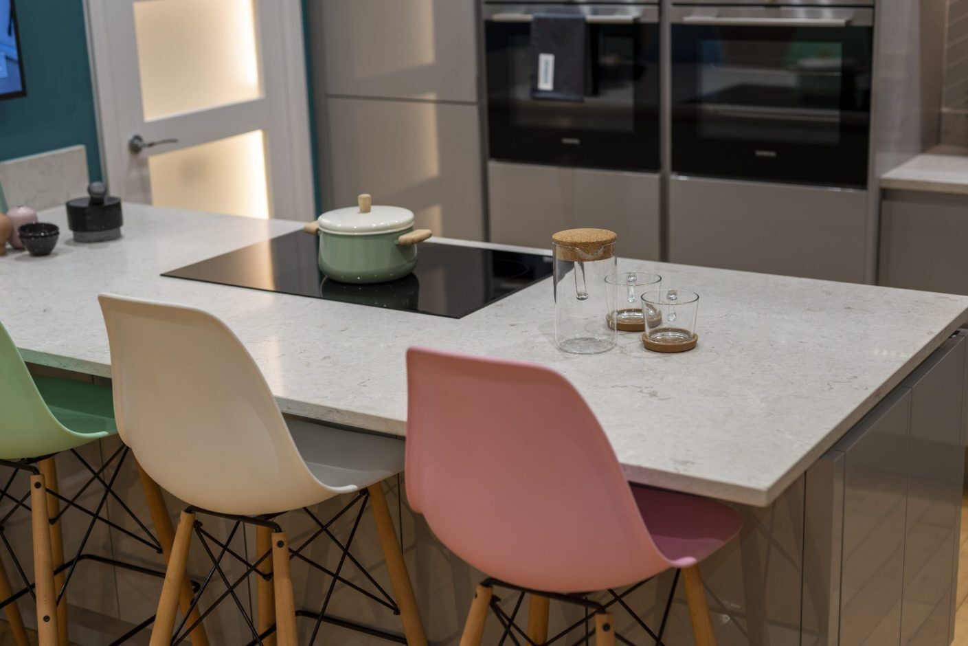 Grey Drift Quartz island worktop with seating and hob area shown from an angled kitchen view