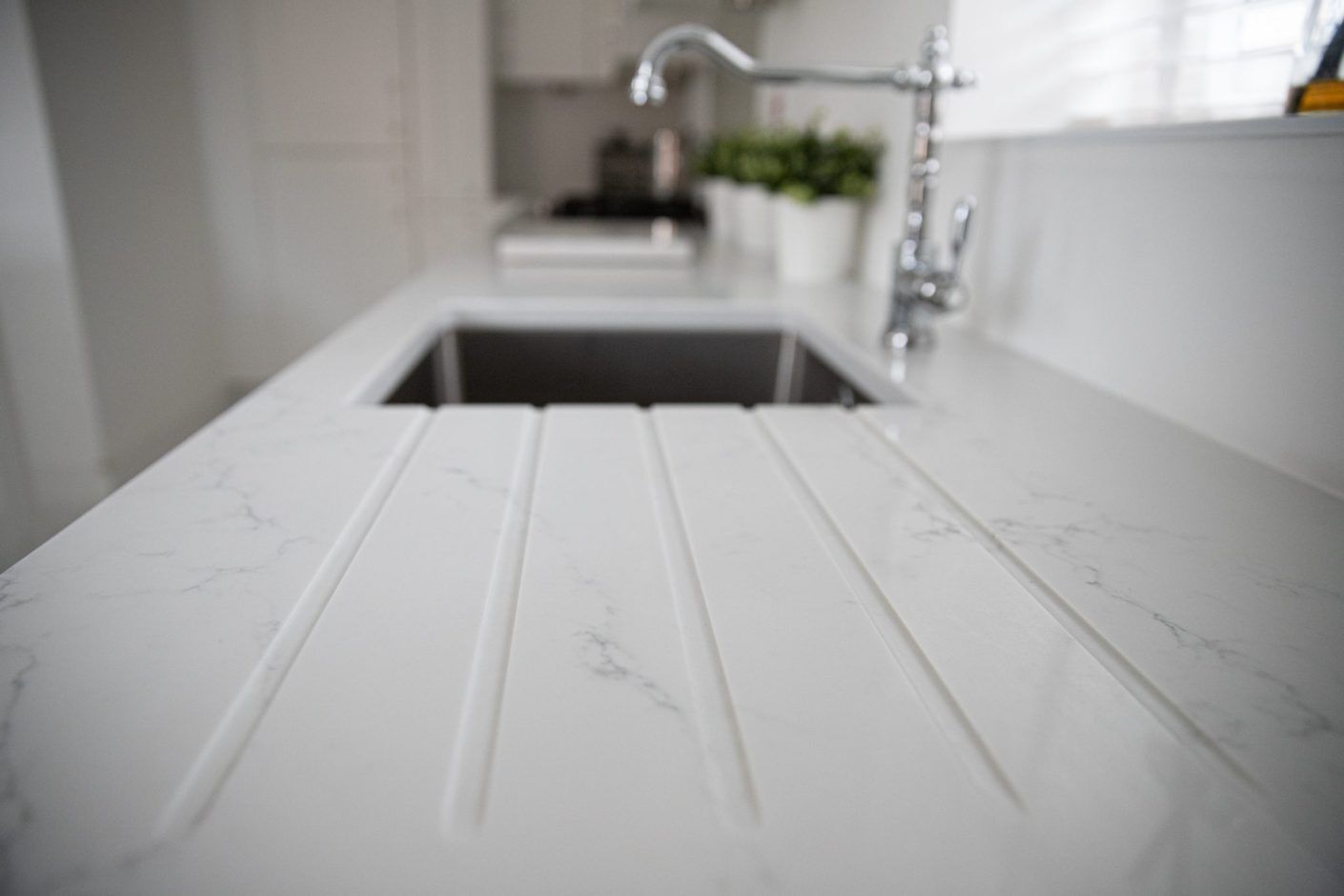 Statuario Bianco Porcelain drainer grooves beside sink showing subtle grey veining