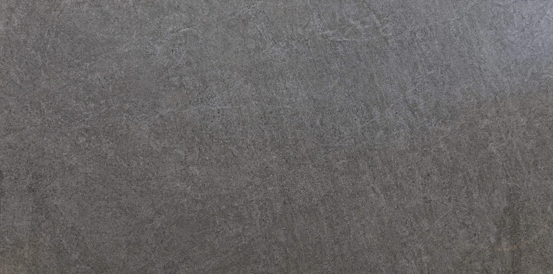 Pierre Bleue Porcelain close-up showing a mid to dark grey stone effect surface with subtle texture and gentle tonal variation
