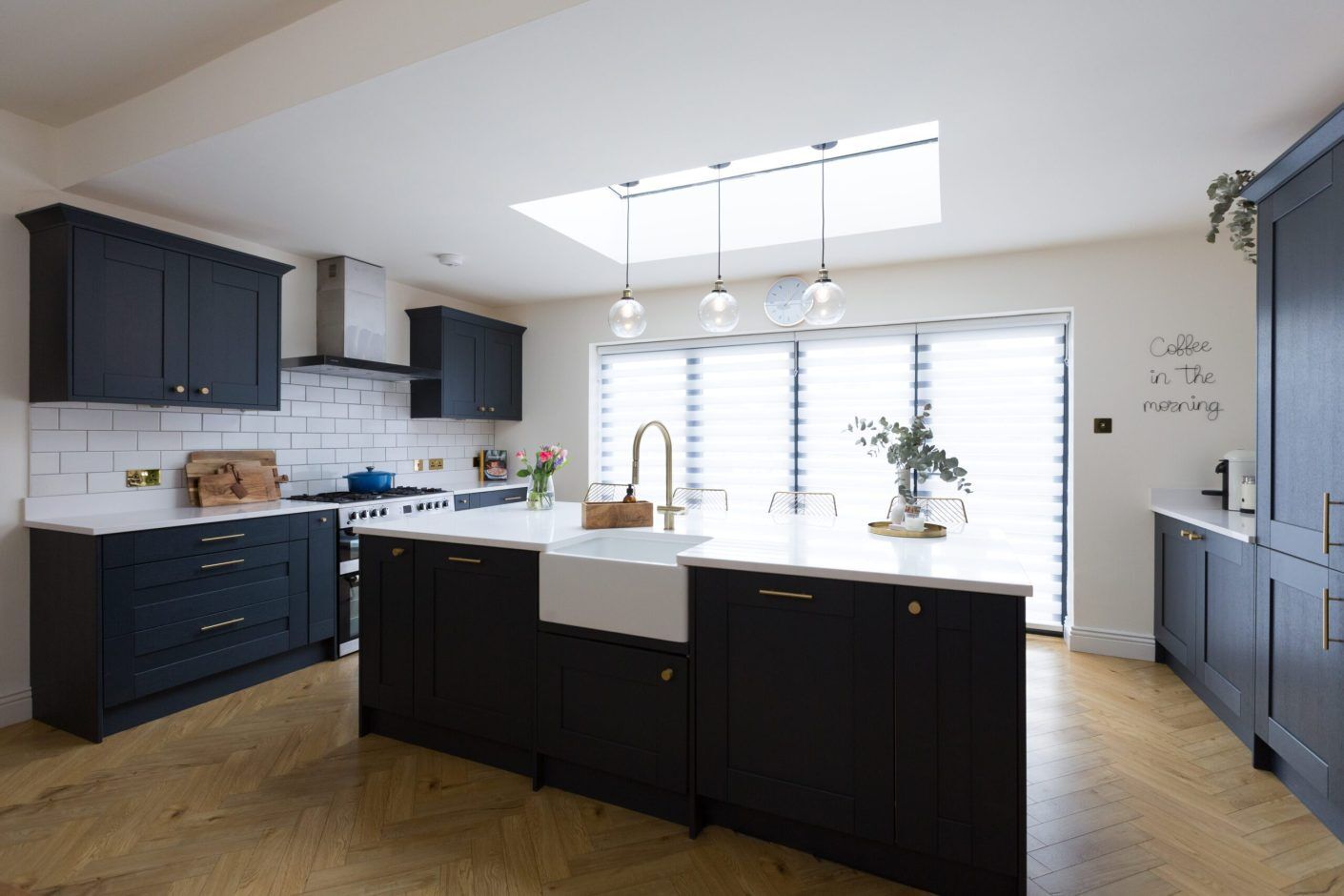 Open-plan kitchen with Blanco Zeus Quartz island worktop and bright white surface contrasting dark cabinetry