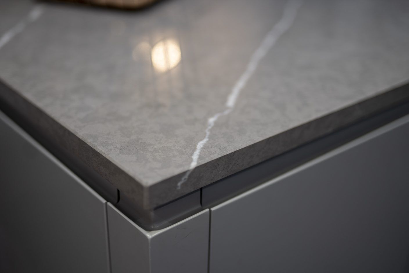 Pietra Grey Quartz worktop edge close-up showing clean mitred corner detail with fine white veining on dark grey