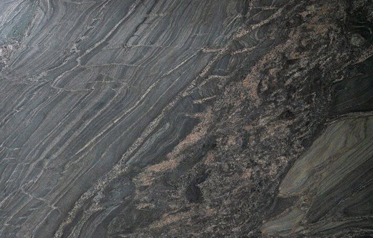 Close up slab photo of Black Storm leather Granite showing sweeping veining, layered movement and a textured finish through the dark surface.