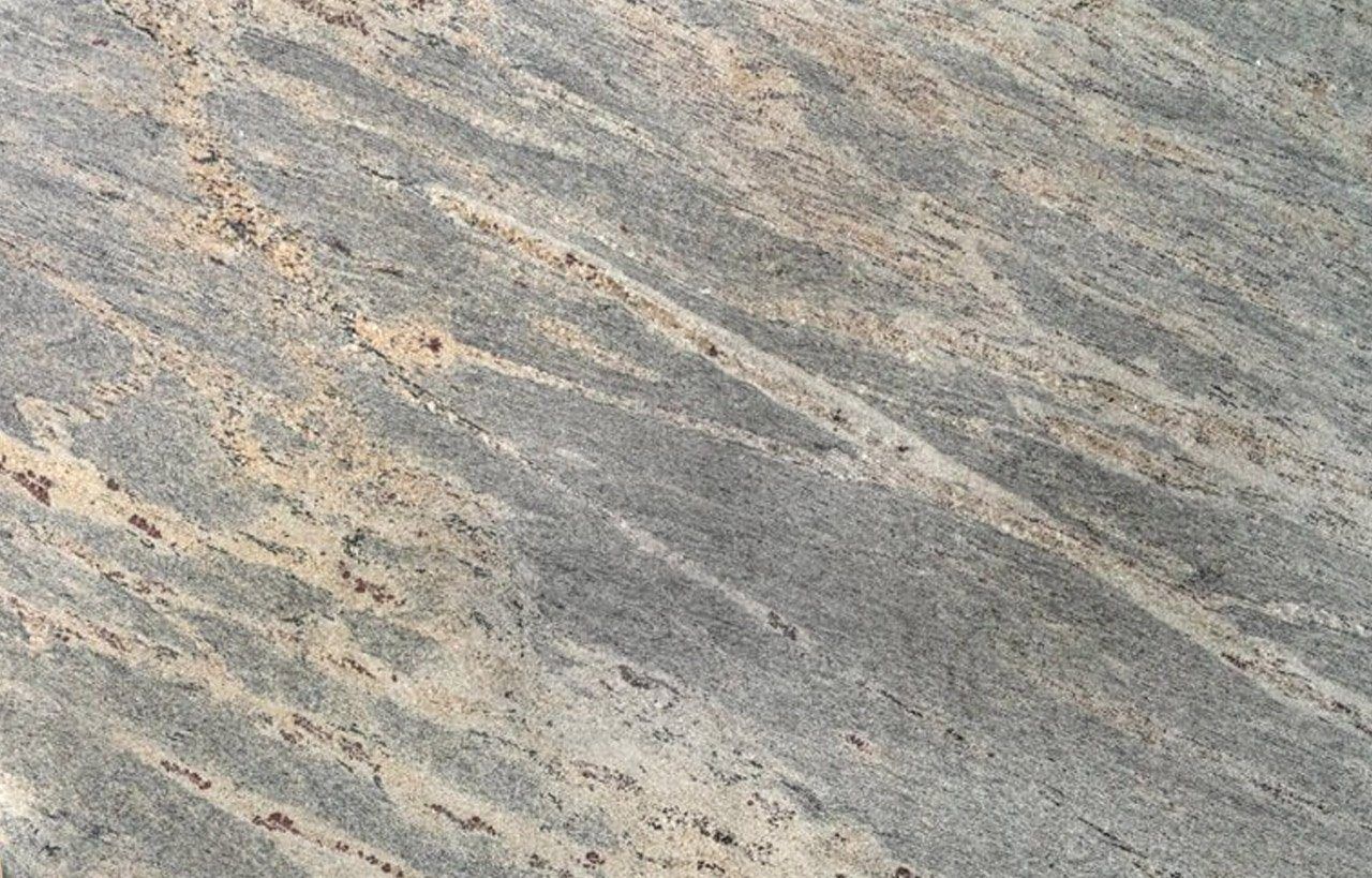 Close up slab photo of Kashmir White Granite showing soft grey movement with warm beige mineral flecks and gentle natural veining.