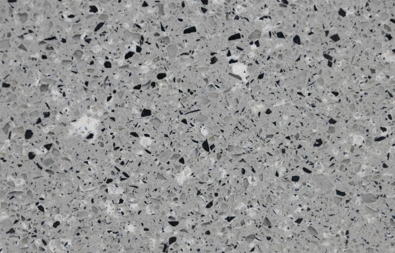 Titanium Quartz slab close-up showing terrazzo-style chips and dark fragments scattered through a grey background