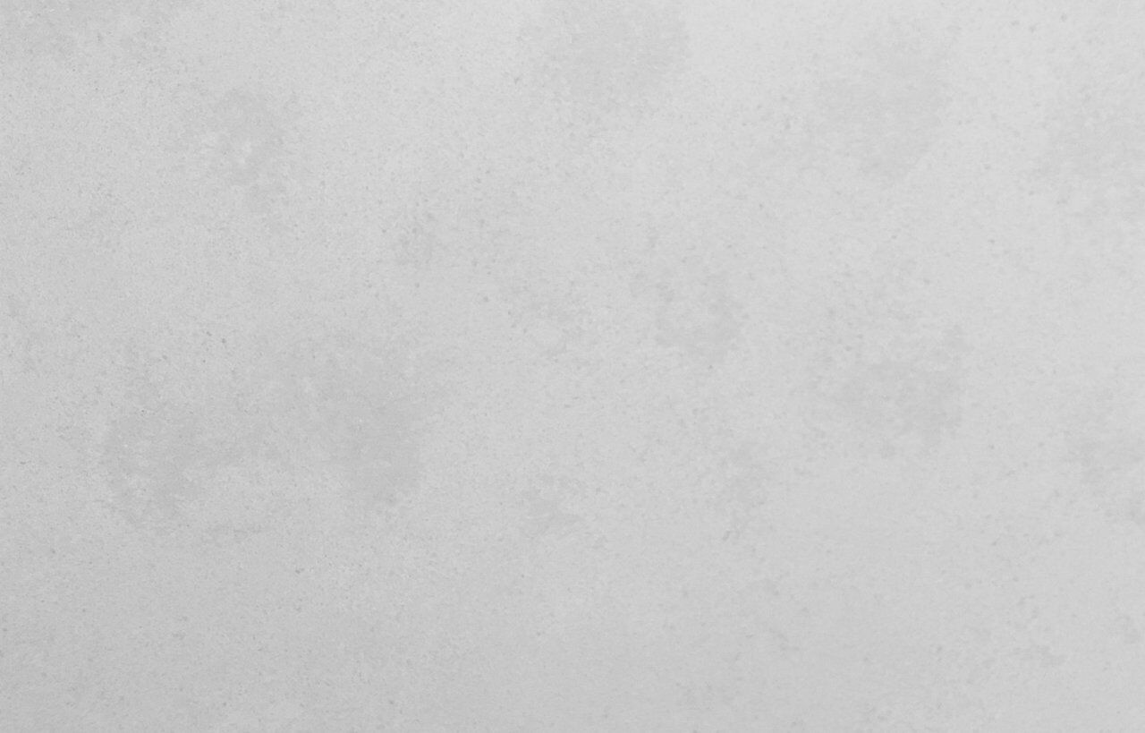 White Concrete Quartz slab close-up showing fine mottling and smooth concrete-effect texture on a light grey base