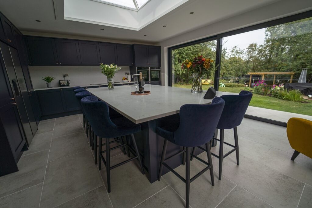Modern kitchen with Carrara Quartz island beneath skylight